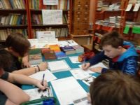 Uczniowie w bibliotece przy stoliku