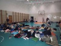 Uczniowie w śpiworach na sali gimnastycznej